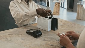 "Midsection of a salesperson handing black-and-white shopping bags with jewelry to a cropped customer, capturing retail service and luxury shopping." - Powered by Shutterstock - Get 15% off with code: PIKWIZARD15
