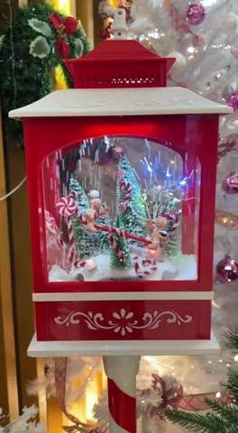 Snow lantern decoration with gingerbread men in a festive snow scene with candy canes and Xmas trees
