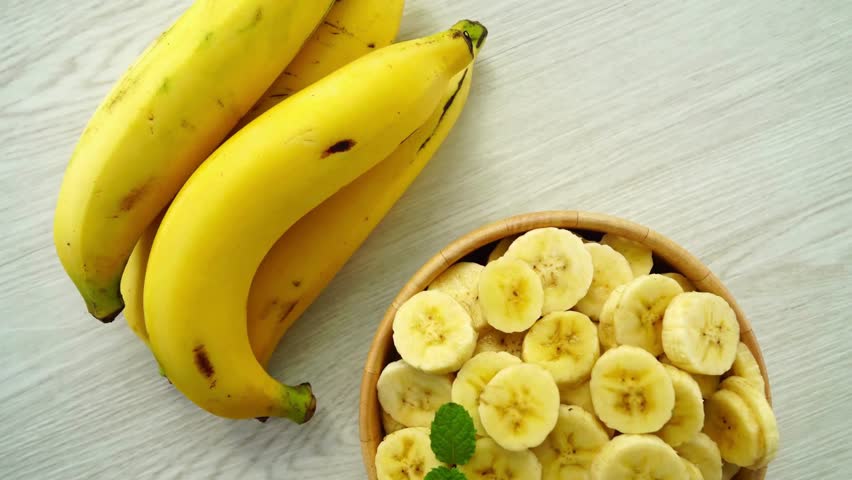 Top-down shot of banana slices arranged in a neat circle on a light surface, perfect for minimal food design, recipes, and healthy meal visuals.
