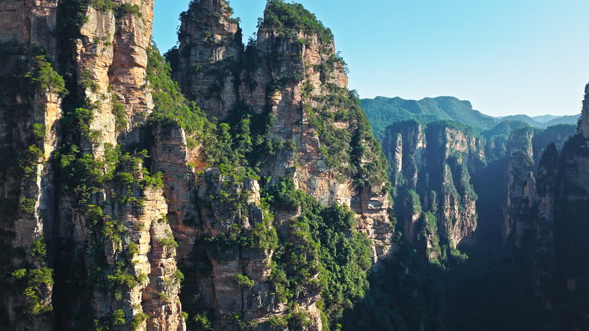 Aerial shot of majestic sandstone pillars and peaks with green forest in Zhangjiajie National Forest Park, Hunan Province, China.