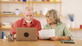 Elderly couple reviewing paperwork and using laptop, discussing and collaborating on financial matters or online tasks - Powered by Shutterstock - Get 15% off with code: PIKWIZARD15