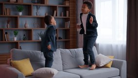 Two little African American boys children jump on couch happy weekend domestic holiday active siblings ethnic kids brothers sons jumping on sofa in cozy living room enjoy playing game funny family - Powered by Shutterstock - Get 15% off with code: PIKWIZARD15