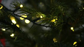 Close-up of a Christmas tree decorated with lanterns and red ribbons in an apartment, Christmas and New Year - Powered by Shutterstock - Get 15% off with code: PIKWIZARD15
