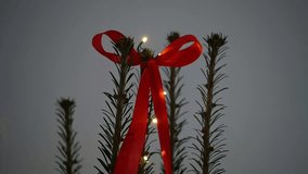 Close-up of a Christmas tree decorated with lanterns and red ribbons in an apartment, Christmas and New Year - Powered by Shutterstock - Get 15% off with code: PIKWIZARD15