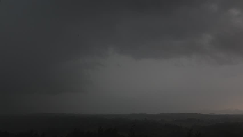 Thunderclouds with flashing lightning over the countryside