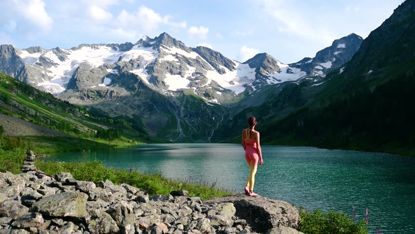 a woman on the shore of a mountain lake - Poperechnoye in Altai