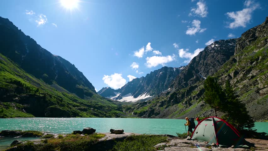 two tourists on the shore of Lake Kuyguk in the Altai Mountains