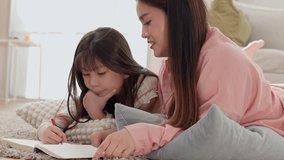 Asian family mother daughter reading book on living room floor with cozy blanket and pillows sharing relaxed caring warm learning moment together - Powered by Shutterstock - Get 15% off with code: PIKWIZARD15