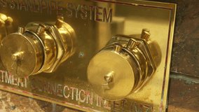 Closeup of industrial pipe fittings, urban safety equipment featuring polished brass and multiple fittings, closeup image of vintage brass piping system with engraved labels and warm patina effects - Powered by Shutterstock - Get 15% off with code: PIKWIZARD15
