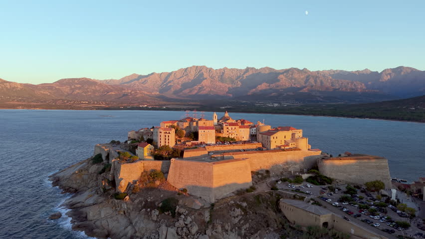 Aerial view of calvi citadel at sunrise with serene waters. Fortress with marina. Corsica. France
