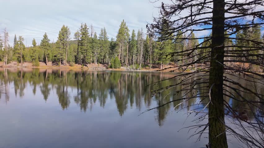 This scenic view captures the majestic Lassen Peak volcano perfectly mirrored in the tranquil waters of Reflection Lake at the national park