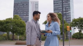 Two young professional entrepreneurs collaborating on a business idea. Happy multiracial coworkers reviewing work on a digital tablet in the city - Powered by Shutterstock - Get 15% off with code: PIKWIZARD15