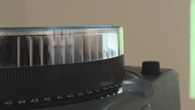 Vintage carousel slide projector running in a dark room with sound, rotating slide tray, warm light beam and changing photos creating a nostalgic analog presentation atmosphere. - Powered by Shutterstock - Get 15% off with code: PIKWIZARD15