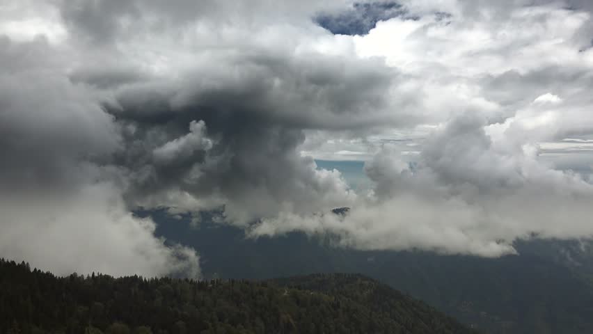 Time lapse storm clouds before rain over dense mixed forest valley in Mount Aspiring National Park. Darkening skies sweep across the wooded valley revealing dramatic weather patterns in New Zealand.