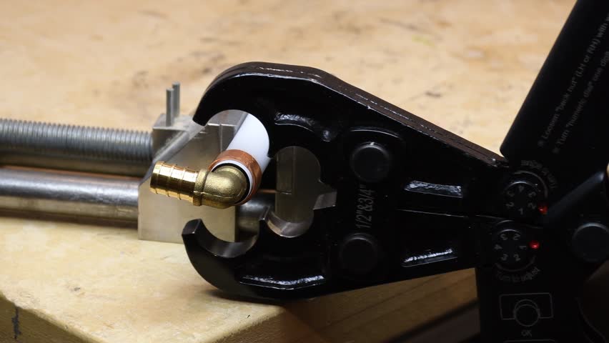 PEX crimping tool. Plastic tubing and elbow with dual size crimping tool.
