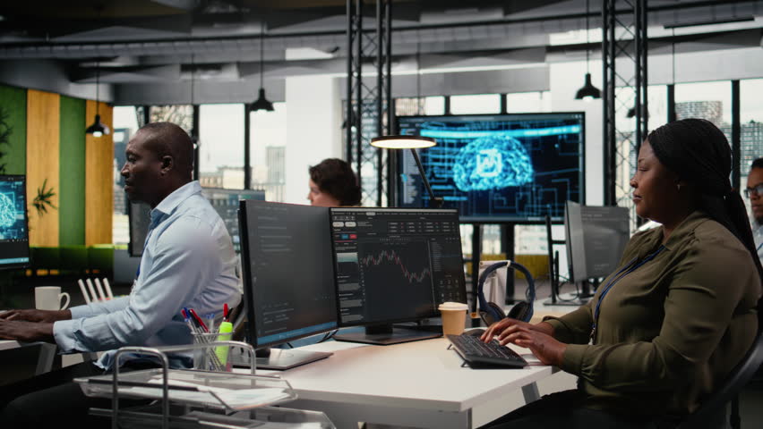 Startup team celebrating in office after seeing live market updates showing stock surging. Tech venture employees excited after securing funding to become publicly traded company, camera A