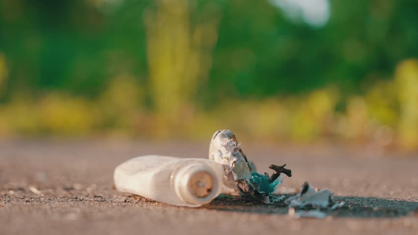 Close-Up: Hands in Blue Latex Gloves Sweeping Plastic Waste with Dustpan and Brush on Asphalt | Environmental Cleanup Action During Golden Hour Sunset | Street Litter Removal