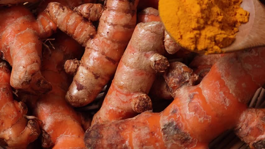 Turmeric powder in wood spoon	