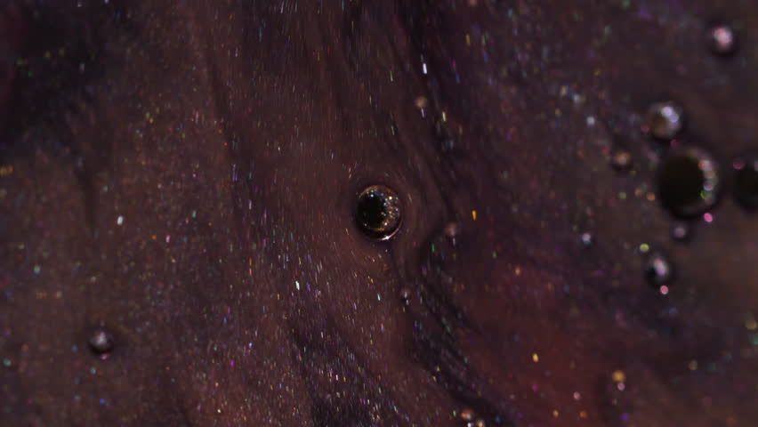 Shimmer spill. Paint water. Defocused yellow golden purple color bubble oil acrylic liquid floating on abstract art bokeh background.