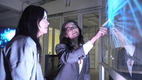 Two people are discussing cybersecurity in an office. They interact with a digital screen showing data and security graphics. The focus is on collaboration and technology use. - Powered by Shutterstock - Get 15% off with code: PIKWIZARD15