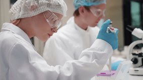 Laboratory technicians analyzing samples in a modern research facility during daytime - Powered by Shutterstock - Get 15% off with code: PIKWIZARD15
