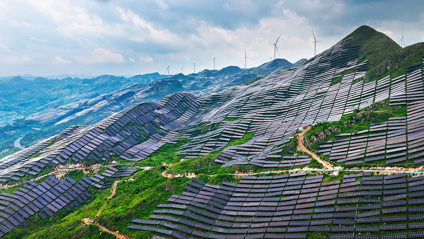 Aerial shot of solar panels and wind turbines on mountain