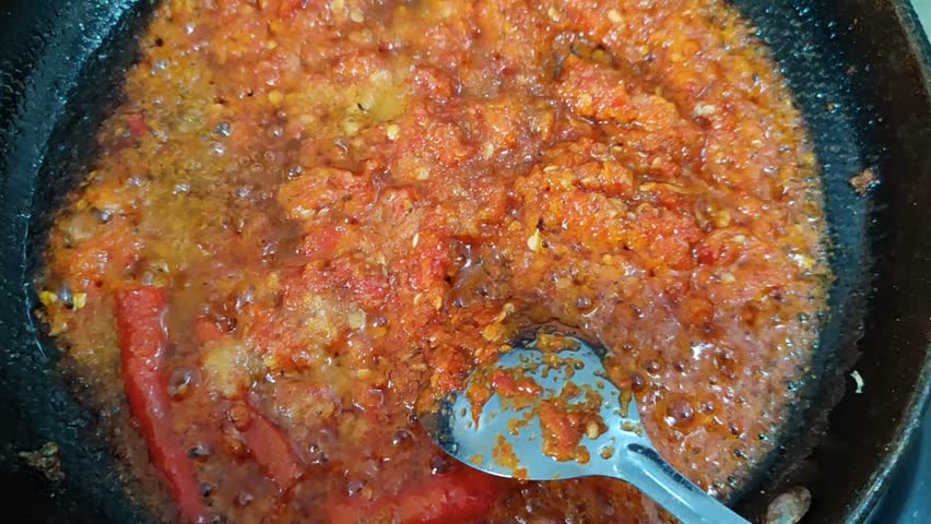 Spicy Chili Sauce Cooking, Stirred with a Spoon. Holiday Cooking.