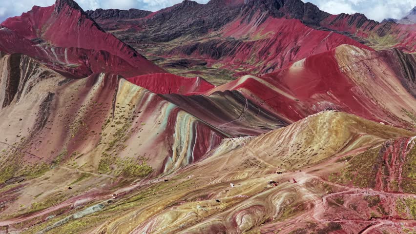 Rainbow Mountain Vinicunca Peru aerial drone morning blue sky Montaña de Siete Colores Palccoyo Pallay Punchu clouds Peruvian Andes Red Valley seven colored striped hills seven colored forward pan up