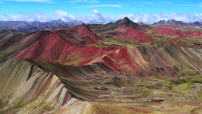 Rainbow Mountain Vinicunca Peru aerial drone morning blue sky Montaña de Siete Colores Palccoyo Pallay Punchu cloud Peruvian Andes Red Valley seven colored striped hills seven colored backwards circle