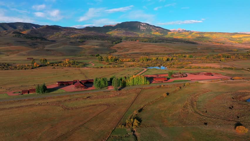 Scenic Fall autumn drive Mill Creek Ranch farm land Ohio Creek Valley Pass near Crested Butte Colorado Gunnison Country aerial drone Mill Castle rock landmark feature colorful Aspen trees circle left