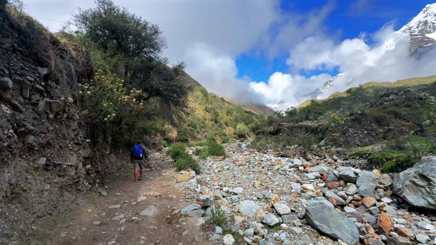Mount Humantay Peruvian Andes snow capped glacier mountain Salcantay Inca trail trek hiker Peru low fog clouds blue sky rainy dry season Laguna Humantay Soray Anta Cusco region nature landscape pan
