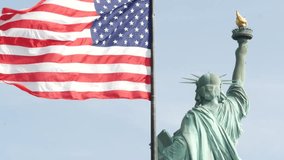Statue of Liberty on Liberty Island, New York, United States. Cooper monument from behind, democracy and patriotism symbol near Manhattan, NYC USA. American flag waving in wind. Independence concept. - Powered by Shutterstock - Get 15% off with code: PIKWIZARD15