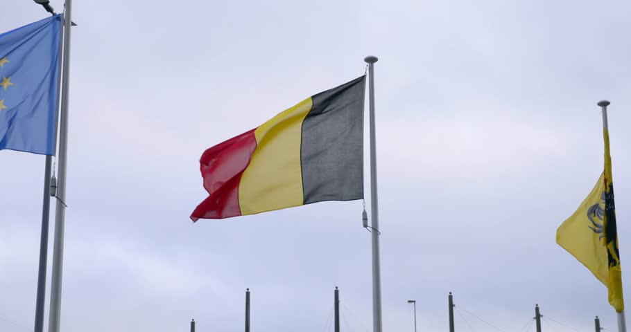 Waving flag of Belgium against a cloudy sky The flag is a national symbol of Belgium representing the country
