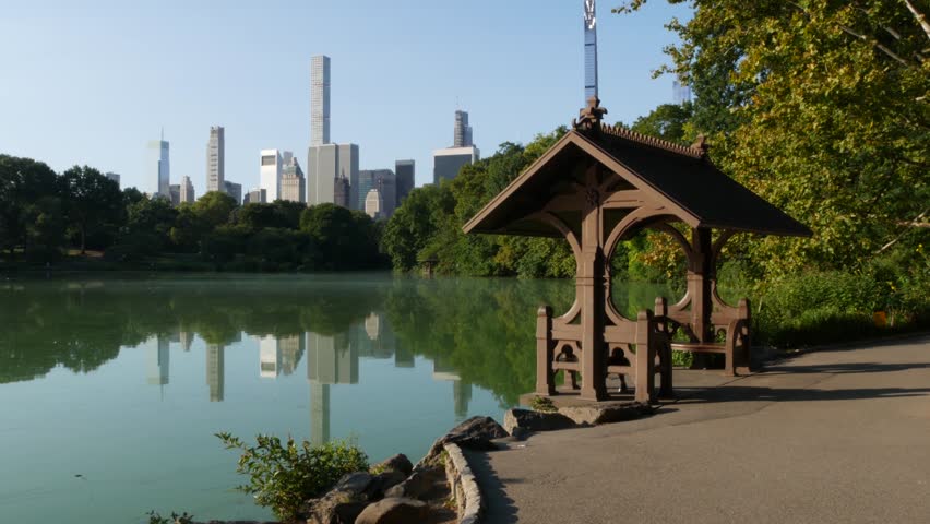 New York City skyline cityscape from Central Park, United States. Midtown skyscraper towers, building architecture and lake in summer. Pond water and greenery in NYC park, USA. Hernshead, alcove view.