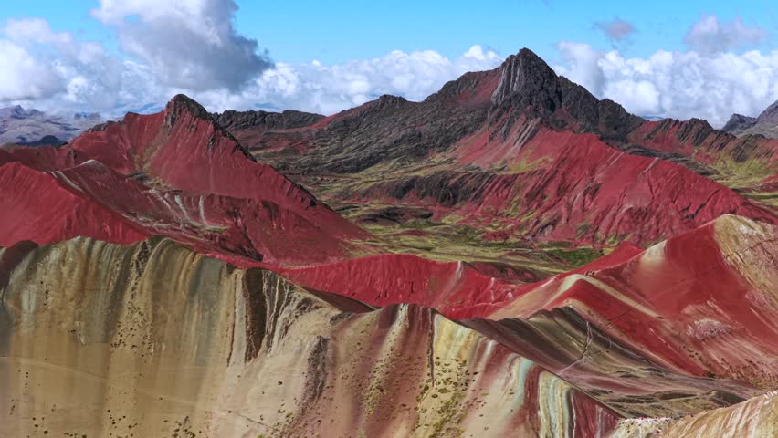 Rainbow Mountain Vinicunca Palccoyo Montaña de Siete Colores Peru aerial drone Peruvian Andes Red Valley striped hills morning cblue sky clouds seven colored Vilcanota Cusco Region parallax circle