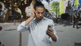 Man holding smartphone, hand to forehead while staring at screen on street in city center; confusion technology problem. - Powered by Shutterstock - Get 15% off with code: PIKWIZARD15