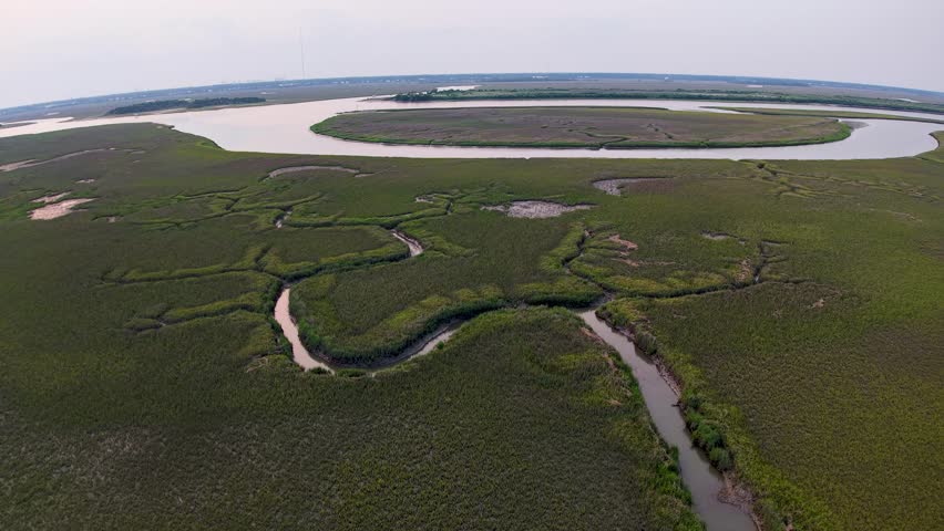 Drone footage displays sweeping marshlands in South Carolina with looping tidal channels and wetlands stretching toward the horizon.