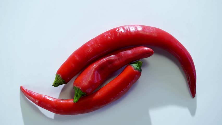 Red chili peppers arranged together on a clean bright surface with soft shadows