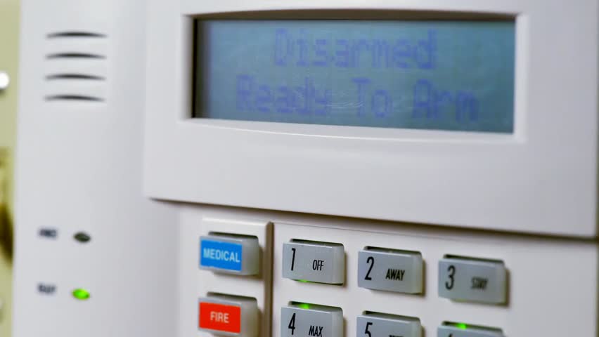Close-up of a man arming a home security panel, illustrating smart home safety, alarm systems, and modern residential security.