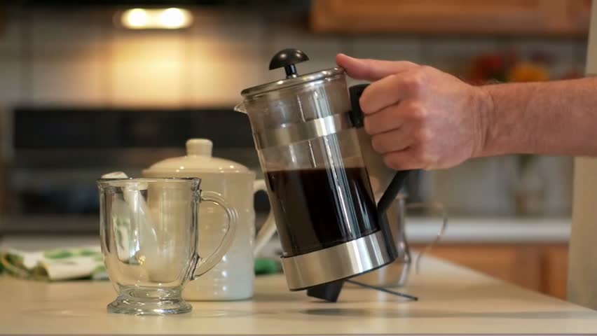 Slow-motion shot of hot coffee being poured into a mug, capturing rich swirling textures, rising steam, and the warm, inviting atmosphere of a fresh brew.
