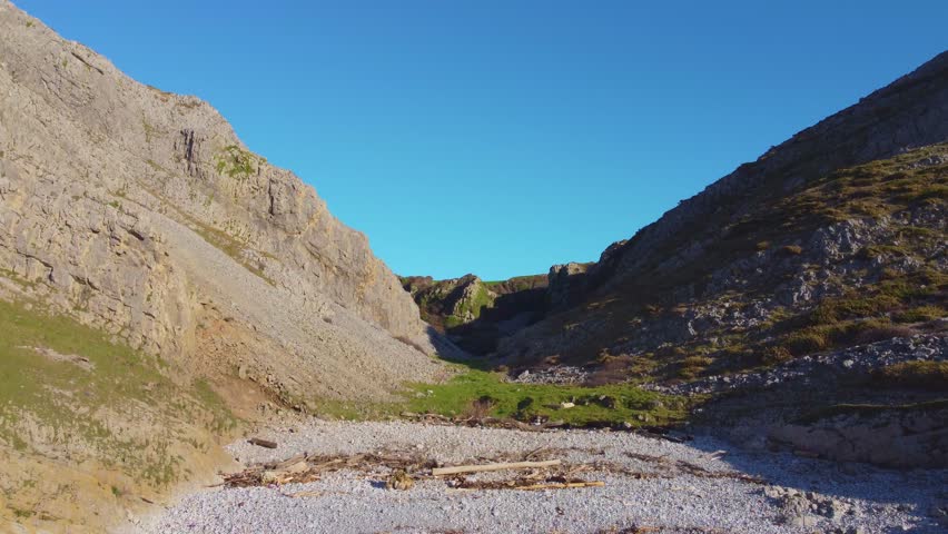 Ascending Aerial of Steep Valley with Crumbling Rocks and Sheer Cliffs. Travel Nature Drone Clip. Beautiful Welsh Gower Peninsula Coast.