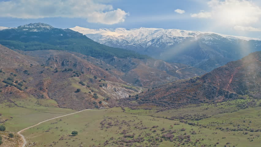 Aerial panoramic view of Sierra Nevada mountains in Spain with snowy peaks green valley sunlight natural landscape beauty nature geography ecology popular travel destination tourism trip in Andalusia