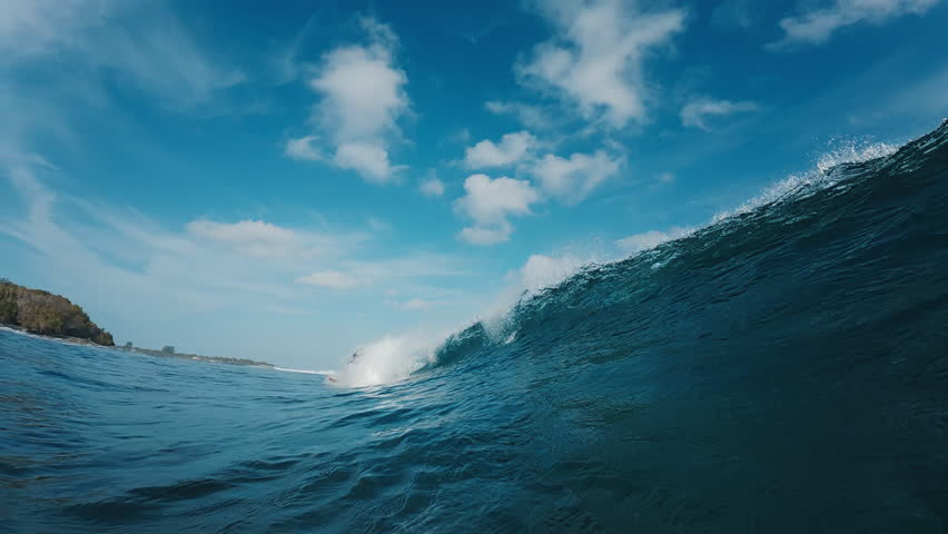 Underwater view of the ocean wave rolling and breaking over the shore in the Maldives