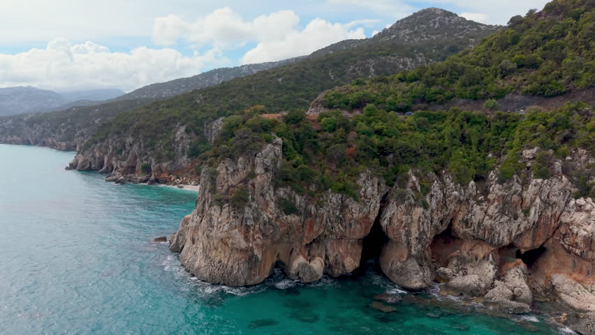 italian coast scenery, golden hour illuminates serene landscape featuring cliffs and tranquil waters. Sardinia