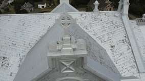 Close-up view of a Celtic cross and a rose window, a circular Gothic-style window, all covered with aluminum sheeting adorning the Saint-Octave-de-Métis Church, Quebec, Canada, 2025. - Powered by Shutterstock - Get 15% off with code: PIKWIZARD15