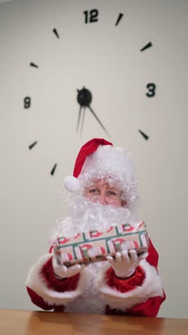 Santa claus showing a gift with a large clock ticking