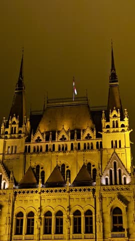 Parliament is illuminated at night in Budapest, Hungary. The Hungarian flag.