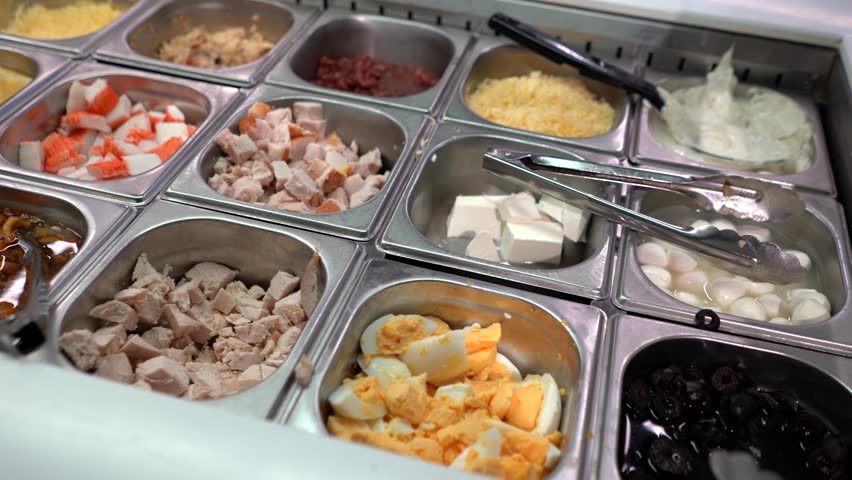 Store counter with a variety of foods and salads including olives, meat, mushrooms, and Korean-style carrot. Fresh, colorful, perfect for culinary and healthy eating