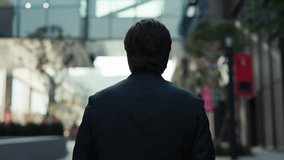 Confident businessman in dark jacket walks along city street backside view. Mature man entrepreneur moves alone across modern financial district. Corporate CEO career growth - Powered by Shutterstock - Get 15% off with code: PIKWIZARD15