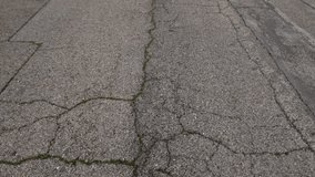 Detailed shot of aged concrete pavement with visible fissures and subtle moss, highlighting erosion and rough surface patterns. - Powered by Shutterstock - Get 15% off with code: PIKWIZARD15